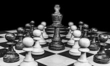 black and white photo of chess pieces on a board