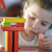 child stacking colorful blocks